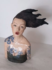 Une sculpture céramique, cuisson raku du buste d'une femme.