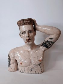 Une sculpture céramique, cuisson raku du buste d'un homme qui fume.