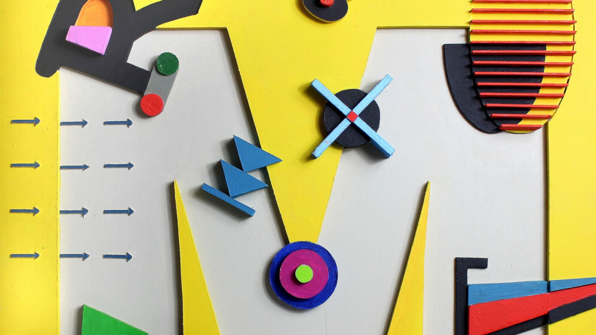 Tableau jaune avec sculpture en forme de M, diverses formes autour.