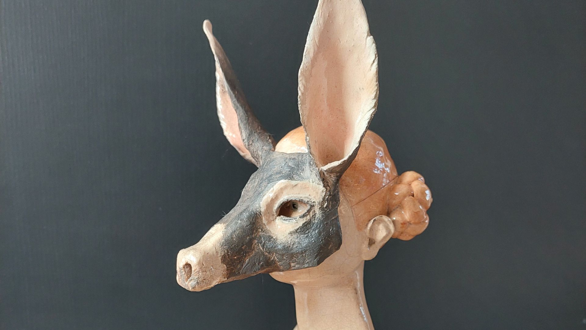 sculpture d'un buste masqué avec visage d'âne