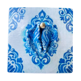 Sculpture d’une vulve avec des motifs bleus.