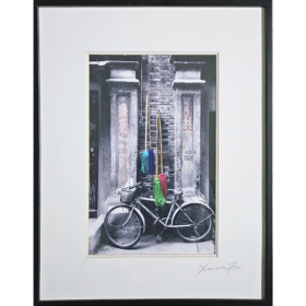 Photographie d'un vélo surplombé de balais colorés