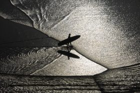 Corinne Dubreuil, Lines, photographie de la plage de la Côte des Basques à Biarritz, où les courbes du rivage, les ombres et les lignes de l’océan composent un paysage graphique.