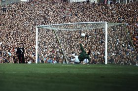 Gerry Cranham, Highbury, Peter Storey transformant un penalty pour Arsenal face à Leeds United, le 11 septembre 1971, tandis que le gardien David Harvey plonge et que les spectateurs de la tribune de Clock End suivent l’action.