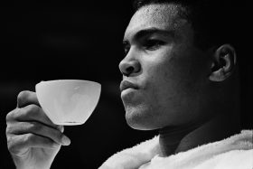 Gerry Cranham, Tea Time, photographie en noir et blanc de Mohamed Ali tenant délicatement une tasse de thé lors d’une conférence de presse à Las Vegas en 1965, avant son combat contre Floyd Patterson.