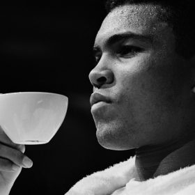 Gerry Cranham, Tea Time, photographie en noir et blanc de Mohamed Ali tenant délicatement une tasse de thé lors d’une conférence de presse à Las Vegas en 1965, avant son combat contre Floyd Patterson.