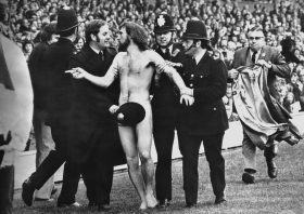 Ian Bradshaw, Twickenham Streaker, Michael O’Brien traversant le terrain de rugby entouré de policiers lors du match Angleterre-France à Twickenham, en 1974.