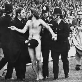 Ian Bradshaw, Twickenham Streaker, Michael O’Brien traversant le terrain de rugby entouré de policiers lors du match Angleterre-France à Twickenham, en 1974.