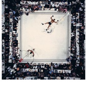 Neil Leifer, Ali-Williams Overhead, Muhammad Ali debout les bras levés au-dessus de Cleveland Williams au sol sur le ring, Houston, 1966.